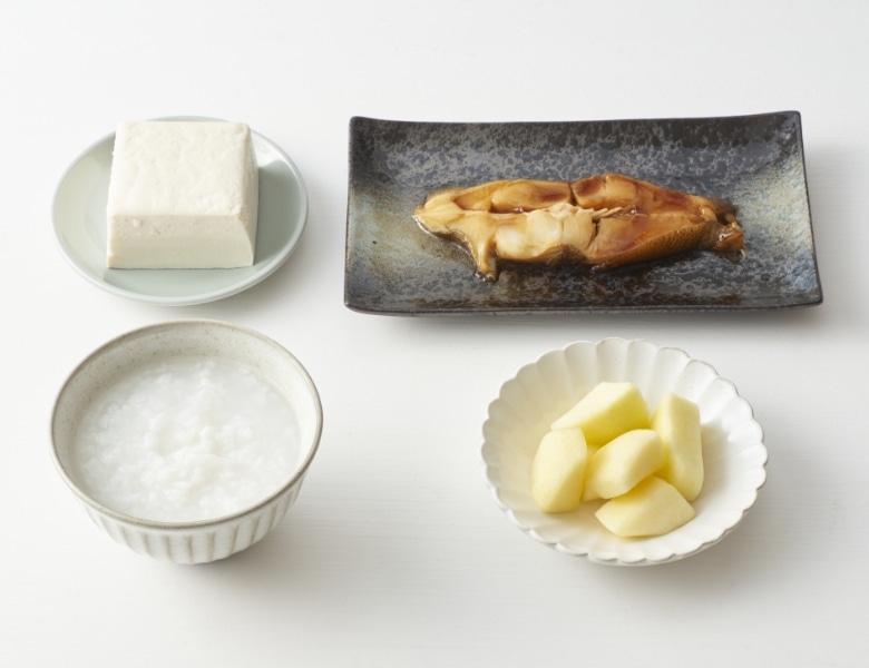 お粥、赤魚の煮付、木綿豆腐、カットりんごの写真