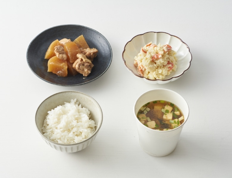 ごはん、鶏大根、ポテトサラダ、豆腐とわかめの味噌汁の写真